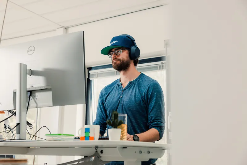 Working at a standing desk with headphones on