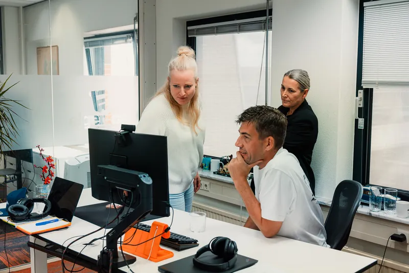 Three colleagues reading one screen together